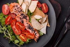 Delicious fresh caesar salad with salmon, lettuce, tomatoes and egg photo