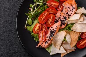 Delicious fresh caesar salad with salmon, lettuce, tomatoes and egg photo