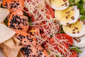 Delicious fresh caesar salad with salmon, lettuce, tomatoes and egg photo