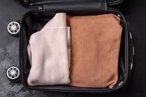 An open suitcase with wheels with clothes inside. Preparing for your trip photo