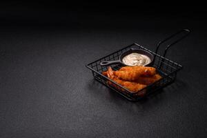 Hot crispy shrimp breaded with salt and spices with white sauce photo