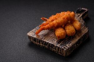 Hot crispy shrimp breaded with salt and spices with white sauce photo