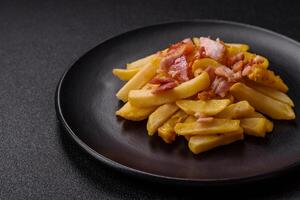 Crispy French fries with pieces of bacon, salt and spices photo