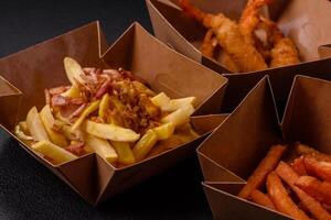 Crispy French fries with pieces of bacon, salt and spices photo