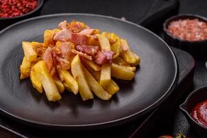 Crispy French fries with pieces of bacon, salt and spices photo