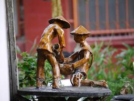 Small farmer statues made of clay are suitable for decoration in the home garden photo