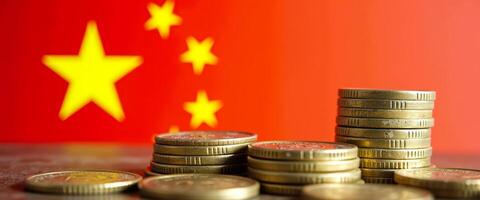 Chinese Yuan Coins Stacked with Blurry Chinese Flag Background photo