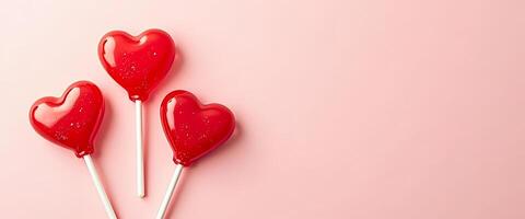 Red heart-shaped lollipops on a pink background photo