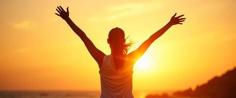 Silhouette of a Woman with Arms Raised in the Sunset photo