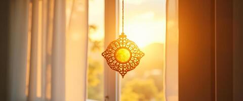 Ornamental Light Fixture Hanging in a Window with Sunlight Streaming In photo