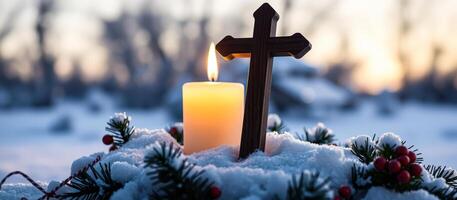 Lit Candle and Cross in Snow with Sunset Background photo
