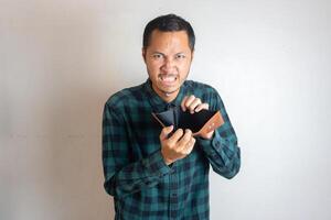 Young asian men is showing his empty wallet with upset emotion photo
