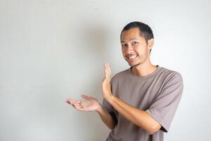Young Adult Asian men pointing finger to the left with smiling face and exited expression with isolated white background photo