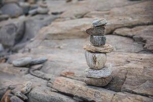 serene beach scene with smooth rocks stacked in a balanced formation. The tranquil atmosphere evokes a sense of zen, harmony, and peace, symbolizing balance and mindfulness in nature photo