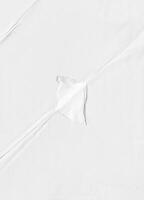 High-resolution white paper texture featuring subtle creases and folds, ideal for backgrounds, design, and overlays. photo