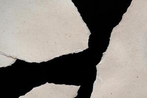 Abstract Torn Paper Texture with Jagged Edges on Black Background photo