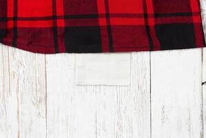 Red and Black Plaid Fabric on Rustic White Wooden Background - Flat Lay Stock Photo