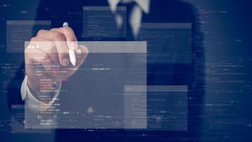 A man in a suit is pointing at a computer screen with code photo