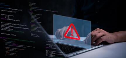 A man using a laptop with a red warning sign on it photo