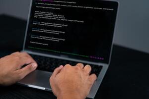 A person typing on a laptop with a programming program on it photo