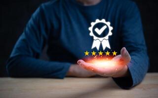 Hand holding a glowing five-star quality assurance badge with a checkmark. Represents excellence and certification. Perfect for quality control, customer satisfaction, and service standards. photo