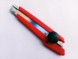 Red cutting tool on white background, close up shot photo