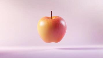 A Single Red and Yellow Apple Floating Against a Pink Background photo