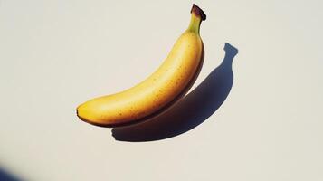 A Single Ripe Banana with a Long Shadow on a White Background photo
