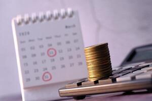 Understanding the Financial Planning and Budgeting Concept Using a Calendar and Various Coins photo