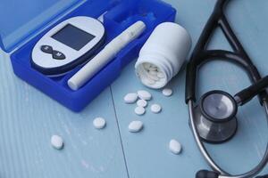 Essential Tools and Medications for Diabetes Management Presented on a Soft Blue Background photo