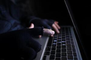 hacker hand stealing data from laptop top down photo