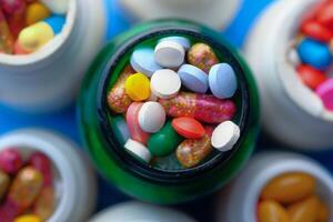 A Vibrant and Colorful Assortment of Various Pills and Capsules Displayed in Bottles photo