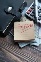 Financial Planning Pay Your Debt with a Reminder Note on Your Desk, Calculator, and Coins photo