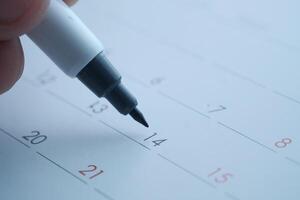 Using a bold black marker to highlight significant dates on a calendar effectively photo