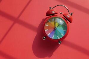 Vibrant and Colorful Alarm Clock Set Against a Bright, Bold Red Background for Display photo