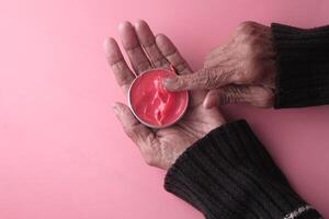Moisturizing Cream Application with Hands on a Soft Pink Background and Aesthetic Surroundings photo