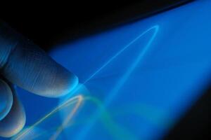 Experiencing Futuristic Touch Interaction with Bright and Vibrant Colorful Light Trails photo