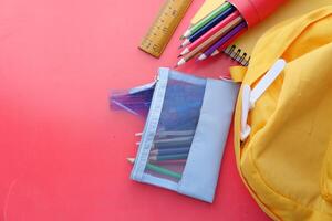 A Vibrant Array of Colorful School Supplies Placed Against a Bright Red Background photo