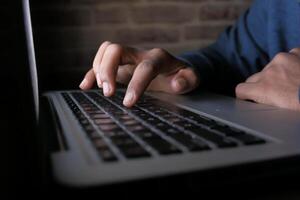 CloseUp of Hands Actively Typing on a Laptop Keyboard in a Busy Work Environment photo