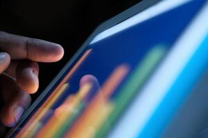 A hand interacting with a data visualization on a tablet screen, highlighting modern technology photo