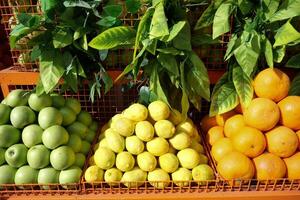 A Vibrant Display of Fresh Citrus Fruits and Green Options at the Local Market Today photo