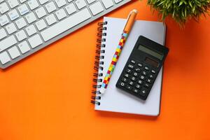 Essential Office Items A Calculator, a Notebook, and a Keyboard Sitting on a Bright Surface photo
