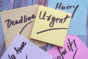 Brightly colored Sticky Notes designed for urgent messages are placed on a wooden surface photo