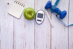 Essential elements for a healthy lifestyle include an apple, a dumbbell, and a health monitor photo