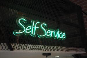 The Self Service Sign glows with vibrant Green Neon Light, boosting visibility and appeal photo
