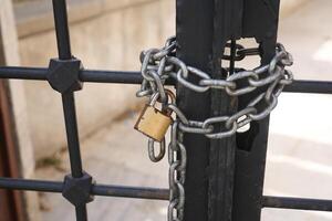 A securely locked gate featuring a chain and padlock for enhanced security and privacy photo