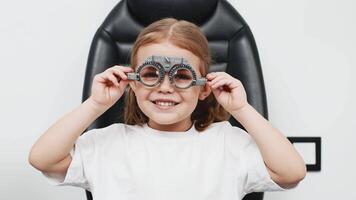 A little girl wearing glasses undergoes vision diagnostics in an ophthalmologist's office. An example of modern methods for diagnosing and treating children's vision. video