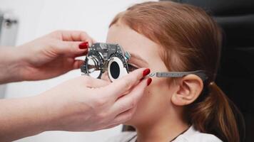 A doctor diagnosing a little girl vision and selecting lenses using a modern medical device. Perfect for illustrating diagnostics and vision correction video