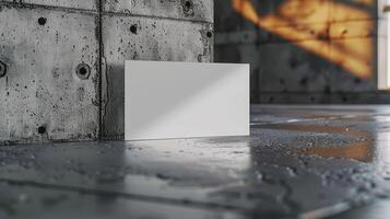 A white card is sitting on a grey concrete floor photo