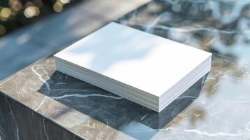 A stack of white paper is on a marble countertop photo